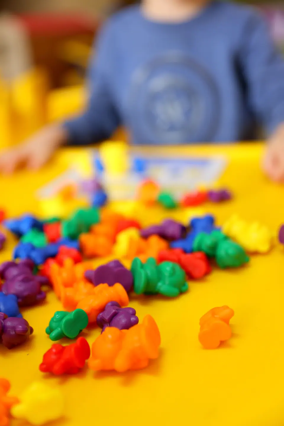 Close-up of colourful counting bears on a yellow table