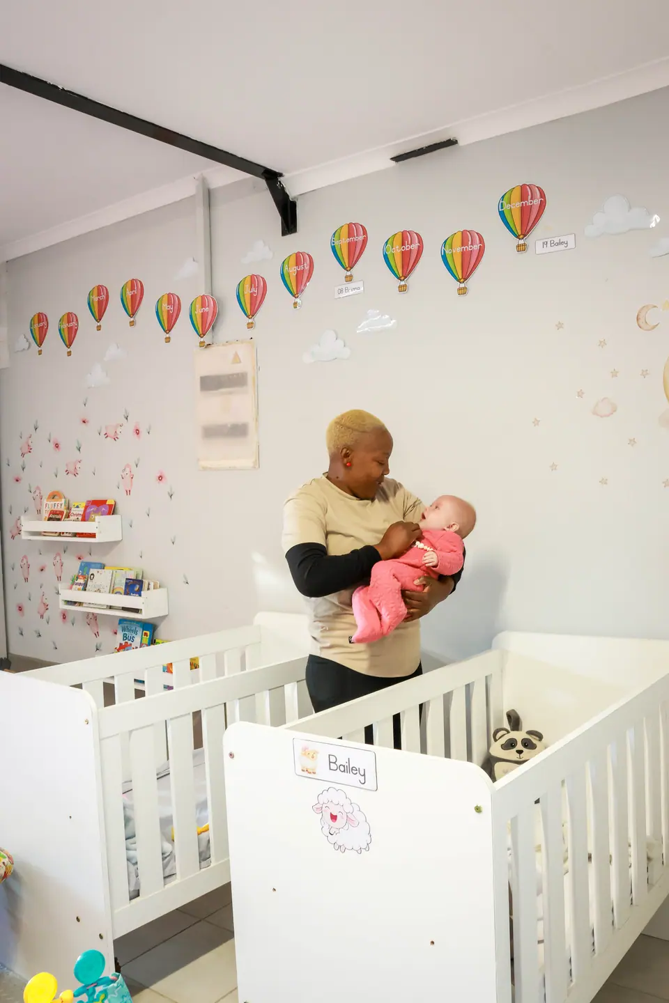 A caregiver cradling a baby in the cot room